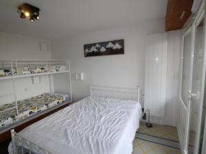 a bedroom with a white bed and shelves at Appartement Auris, 3 pièces, 6 personnes - FR-1-297-156 in Auris