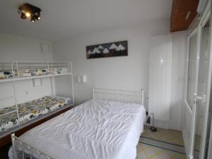 a bedroom with a white bed and shelves at Appartement moderne 3 pièces, 6 couchages à 150m des pistes - FR-1-297-156 in Auris