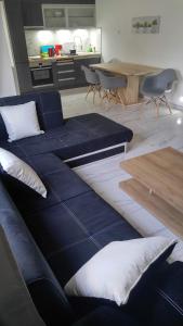un soggiorno con divano blu e tavolo di New!90sqm10minAirport2bedrooms a Salonicco