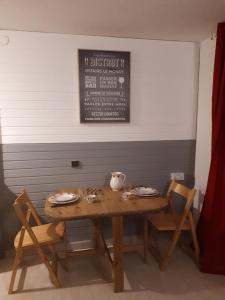 drewniany stół z dwoma krzesłami i wazonem w obiekcie Studio Near The Slopes At La Plagne w mieście La Plagne Tarentaise