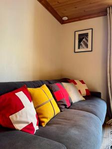un sofá con almohadas coloridas en una habitación en Chic And Cosy Apt With Balcony In Megeve en Megève