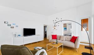 a living room with a couch and a tv at Penthouse Hygge Meerblick am Strand in Olpenitz