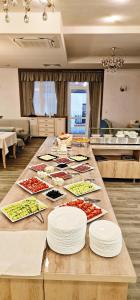 a table with plates of food on it in a kitchen at ApartHotel Olympus Plaza in Kranevo