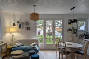 ein Wohnzimmer mit einem Sofa und einem Tisch in der Unterkunft Spacious quiet nest with garden near the sea in La Tranche-sur-Mer