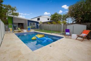 a swimming pool with a pool noodle in a backyard at 23 Bryce St Moffat Beach in Caloundra
