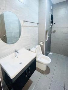 La salle de bains est pourvue d'un lavabo, de toilettes et d'un miroir. dans l'établissement Urban Serviced Apartment, à Bandar Penawar