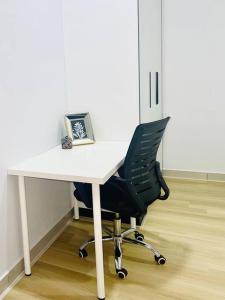a white desk with a black chair in an office at Urban Serviced Apartment in Bandar Penawar