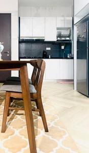 - une table en bois avec une chaise dans la cuisine dans l'établissement Urban Serviced Apartment, à Bandar Penawar