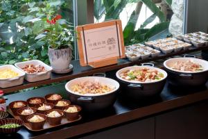 a buffet with bowls of food on a table at Hotel Resol Trinity Naha in Naha