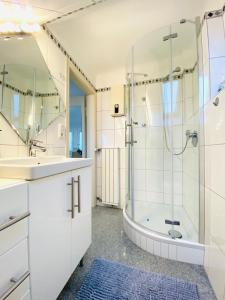 a bathroom with a shower and a sink and a tub at Ferienwohnung Molter in Oberthal