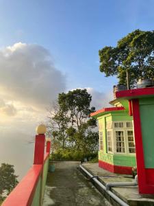 a colorful building next to a body of water at Flower Patch Homestay in Kalimpong
