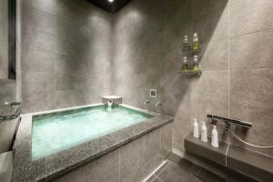 a bathroom with a swimming pool in a shower at HOTEL BEACON ONOMICHI in Onomichi