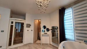 łazienka z wanną i żyrandolem w obiekcie Appt 4P, parking, Disney direct, Vallée Village w mieście Serris +34 zdjęcia