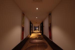 a hallway with a long corridor with paintings on the walls at Hotel Cenneys Gateway in Salem