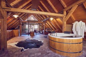 a large room with a tub in a wooden building at Mill Apartments in Český Krumlov