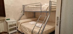a bunk bed with a ladder in a small room at Casa soggiorno il Quetzales in Valenza
