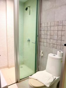 a bathroom with a glass shower with a toilet at Swana Bangkok Hotel in Bangkok