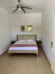 a bedroom with a bed and a ceiling fan at Holiday house near the beach - 2 in 1 in Perítheia