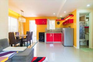 eine Küche mit einem Kühlschrank und einem Tisch mit Stühlen in der Unterkunft Brew Home - 3 Bedroom House in Bacolod City