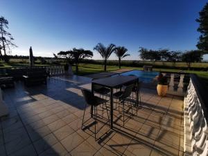 a patio with a table and chairs next to a pool at Blackwood Eco Lodge in Witbank