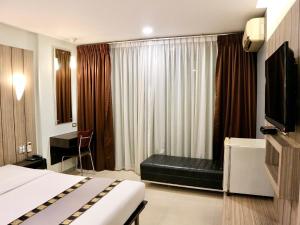 a hotel room with a bed and a window at Swana Bangkok Hotel in Bangkok