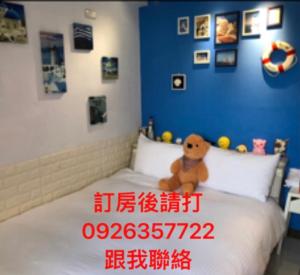 un osito de peluche sentado encima de una cama en Jacky's House Ximen en Taipéi