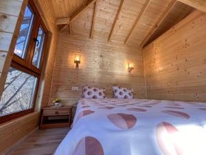 1 dormitorio con 1 cama grande en una cabaña de madera en Casute in copac & Case A frame, en Porumbacu de Sus
