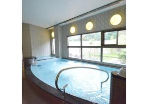 a large pool of water in a room with windows at Isawa no sato / Vacation STAY 61566 in Shiso