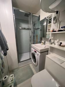 a bathroom with a shower and a washing machine at La désirade full south in La Ciotat