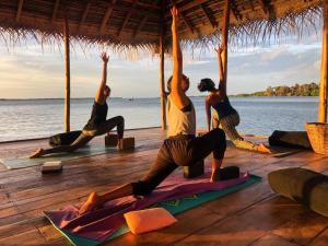 een groep mensen die yoga doen op het strand bij Anawasal in Kalpitiya