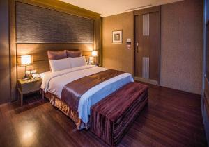 um quarto de hotel com uma cama grande e duas lâmpadas em One + One Motel em Longtan