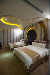een hotelkamer met 2 bedden en een geel plafond bij One + One Motel in Longtan