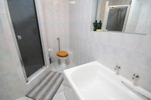 a bathroom with a toilet and a shower and a sink at 139 Longships - Cozy Double Room in Plettenberg Bay