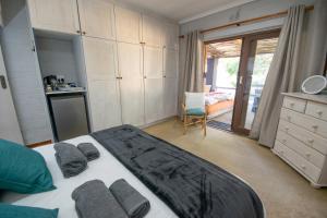 a bedroom with a large bed with towels on it at 139 Longships - Cozy Double Room in Plettenberg Bay