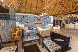 ein Zimmer mit Stühlen, Tischen und einem Wandgemälde in der Unterkunft Nirvana Heights Hotel in Gisenyi