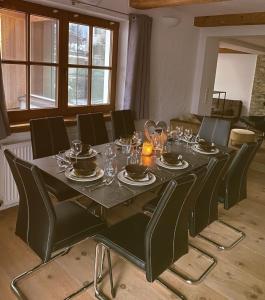 czarny stół z czarnymi krzesłami i jadalnia w obiekcie EMMA´s Chalet w Mayrhofen