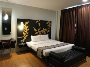 a bedroom with a bed with a black and gold headboard at Swana Bangkok Hotel in Bangkok