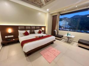 a bedroom with a large bed and a large window at Hotel White Orchid Dalhausie in Dalhousie