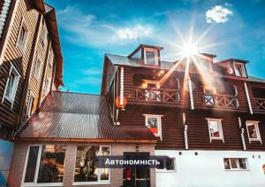 un bâtiment en bois avec le soleil brillant sur lui dans l'établissement Gremi Hotel, à Dragobrat