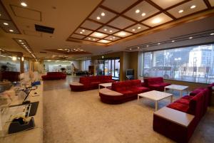 a lobby with red couches and tables in a building at Nasushiobara Ichimantei in Nasushiobara