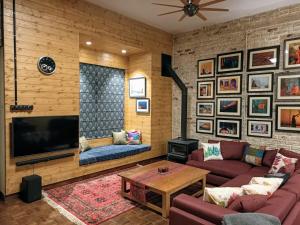 sala de estar con sofá y TV en SaffronStays Ekam Walnut Suite, Chail en Kandāghāt