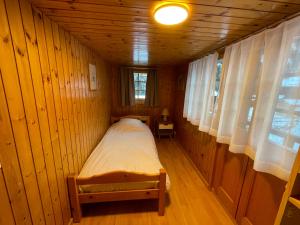 ein kleines Zimmer mit einem Bett in einer Holzhütte in der Unterkunft Apartment Moulin in Grimentz