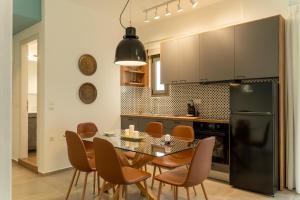a kitchen with a table and chairs and a black refrigerator at Esperos Studios and Apartments, #1 and #5 in Stalís