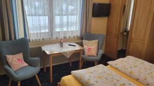 Pokój ze stołem, 2 krzesłami, stołem i łóżkiem w obiekcie Gästehaus Raab w mieście Ranten