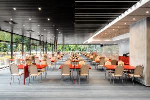 a dining room with tables and chairs and windows at Hotel Thermal in Karlovy Vary