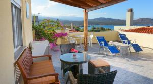 a patio with a table and chairs and a view of the water at Villa Minoas Apartments in Istron
