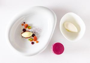 ディジョンにあるオステルリ デュ シャポー ルージュの白皿(果物、スパイス付)