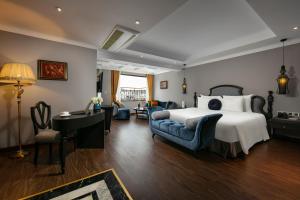 a bedroom with a bed and a desk and chairs at Hanoi L'Heritage Hotel & Gym - Spa in Hanoi