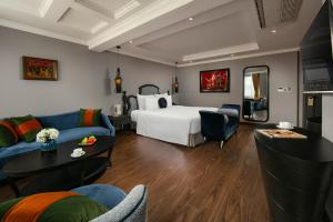 una camera d'albergo con letto e divano di Hanoi L'Heritage Hotel & Gym - Spa a Hanoi