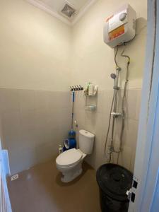 La petite salle de bains est pourvue d'une douche et de toilettes. dans l'établissement Villa Aslam Kayana Batu, à Karangploso